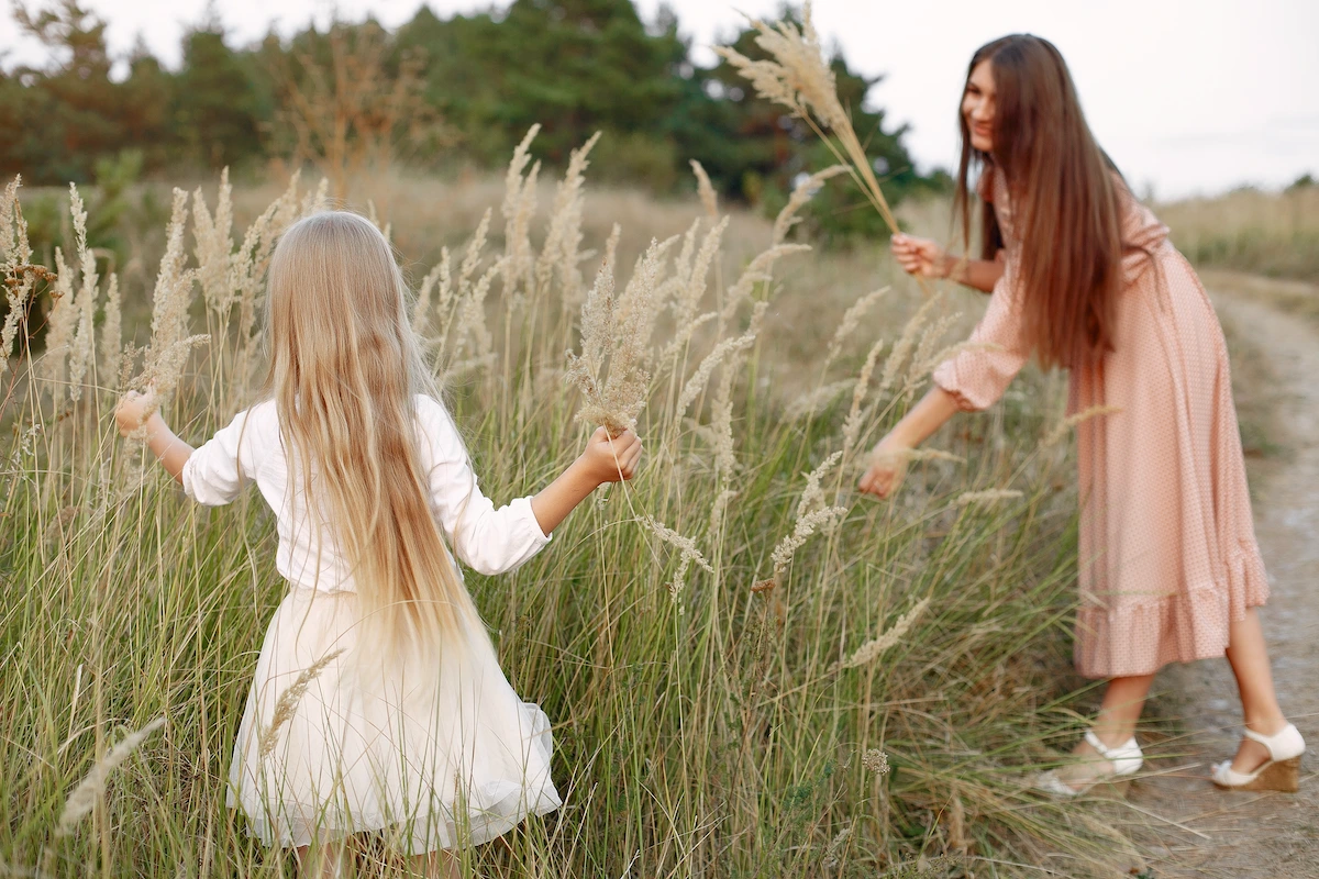 Modestly dressed woman picking flowers with her daughter