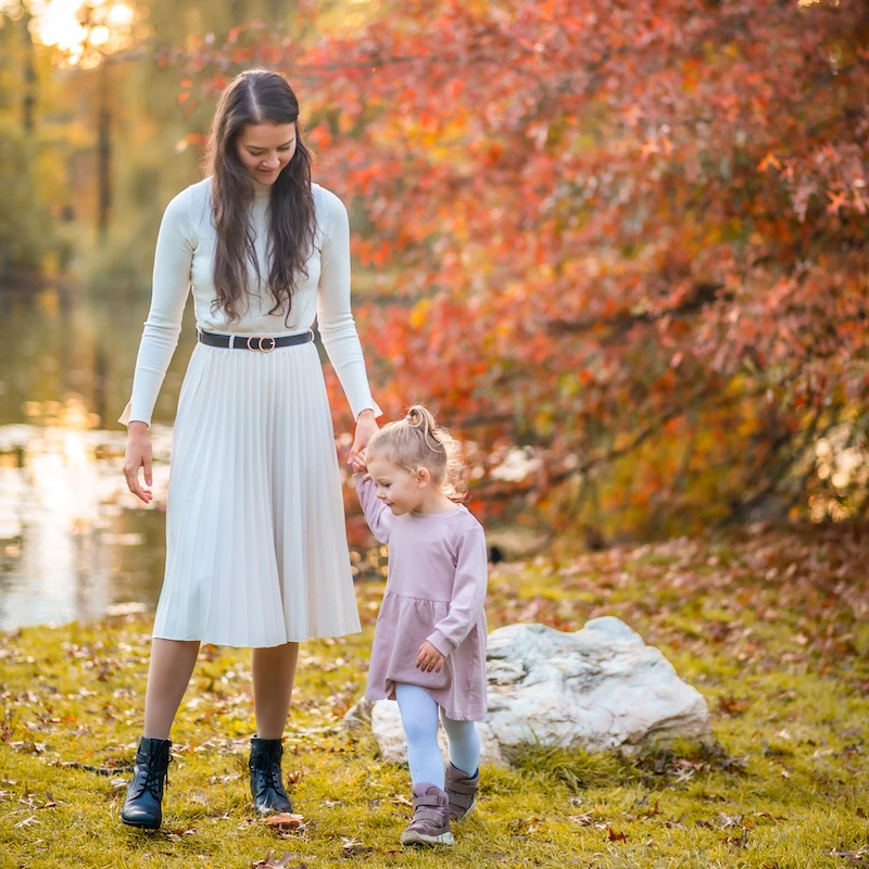 Modestly dressed woman holder her daughter's hand in a field